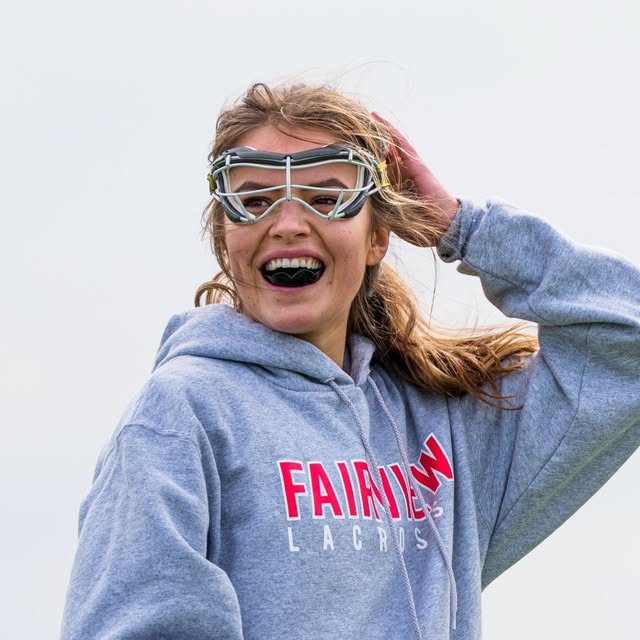 A Fairview Lacrosse player smiling in a Fairview Lacrosse hoodie